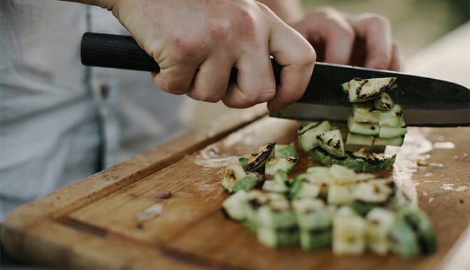 Man chopping zucchini and preparing a healthy meal